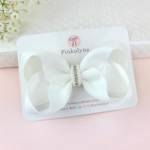 White satin flower girl hair bow with pearl and rhinestone center