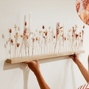 Wood wall flower arrangement with tall dried stems in neutral beige and rust tones