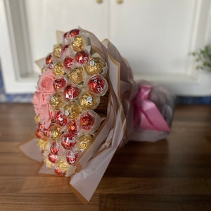Chocolate bouquet with gold foil chocolates, wrapped in pink and white paper.