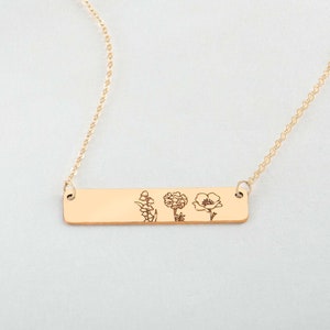 Gold bar necklace with engraved wildflower charm on a fine chain