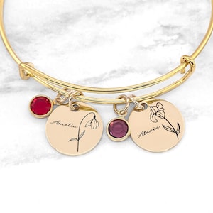 Gold-tone birthstone bracelet with round engraved flower charms and red and purple stones