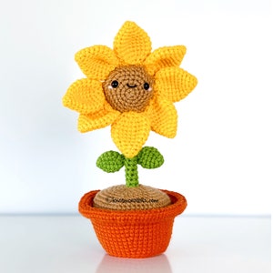 Crochet sunflower amigurumi with green leaves in an orange terracotta pot
