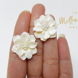 White flower pearl stud earrings with round pearl centers and textured petals