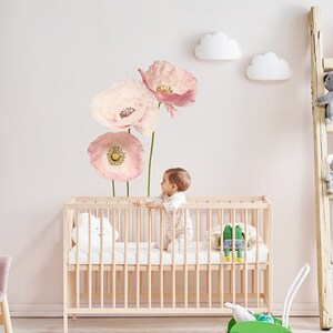 Pink flower wall decals with peony-style blooms above a baby crib