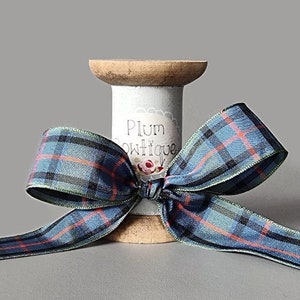 Tartan ribbon spool with blue, red, and gray plaid ribbon bow, 25mm width