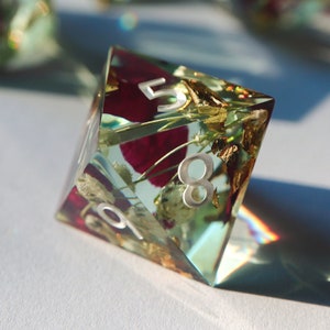 Resin RPG die with floral inclusions, showing the number 8