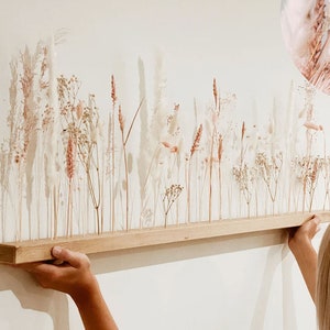 Wooden dried-flower arrangement with tall pale stems and soft pink accents