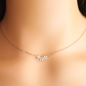 Dainty gold-tone flower necklace with central cluster pendant and small stone petals