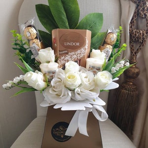 Gift hamper with Lindor chocolate box, Ferrero chocolates, and white rose bouquet