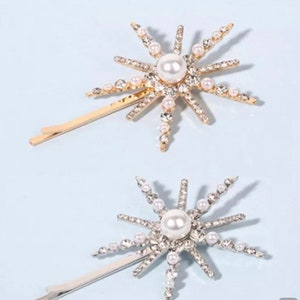 Star hair clips with pearl and rhinestone sunburst design, one gold and one silver