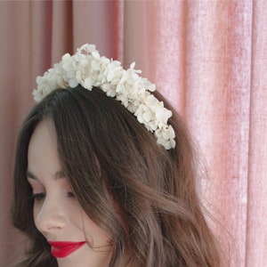 White flower crown headband with clustered blossoms across the hair