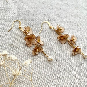 Gold-plated floral dangle earrings with hook backs and small bead accents