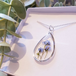 Silver teardrop pendant necklace with glass oval and pressed forget-me-not flowers
