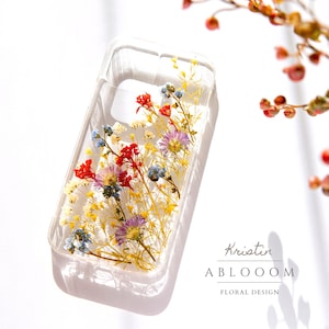 Pressed flower phone case with clear background and colorful dried blooms in a slim wrap
