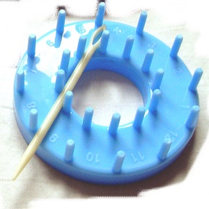 Round flower loom tool with blue peg ring and wooden latch tool for making circular flowers