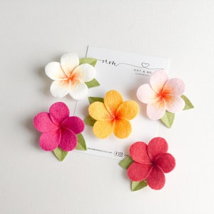 Set of flower hair clips with pink, orange, and white blossoms and green leaves