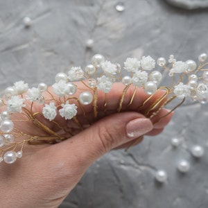 Bridal pearl and baby’s breath hair pin headpiece with white blossoms and gold accents