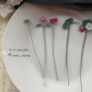 Handmade crochet flower bookmarks with yarn stems and pink, blue, and green blooms