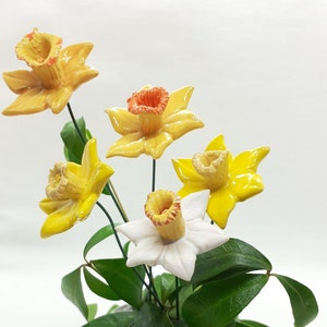 Ceramic daffodil flower set with yellow blooms, orange centers, white flower, green leaves
