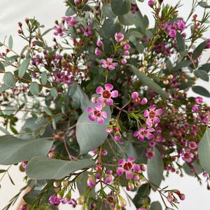 Floral bouquet with eucalyptus greenery and clusters of small pink flowers