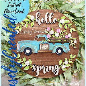 Round spring door hanger sign SVG with blue vintage truck and floral leaves, “hello spring” text