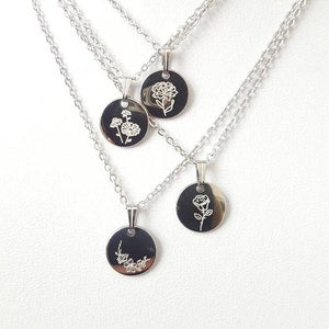Dainty birth flower necklace with four round black enamel pendants and silver chain