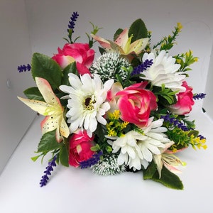 Artificial garden flower bouquet with pink and white blooms in green planter
