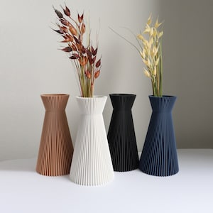 Ribbed dry flower vases with dried stems in terracotta, white, black and blue