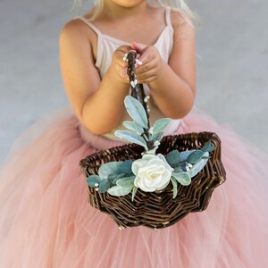 Small decorated flower girl basket with white flower and teal greenery