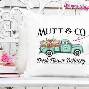 White pillow cover with Mutt & Co text and colorful vintage truck flower delivery graphic
