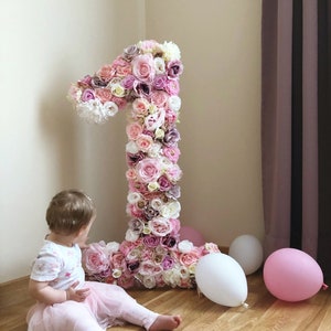 Large floral letter decor made of pink and purple roses with ribbon trim