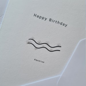 Birthday card with Happy Birthday text and Aquarius symbol, monochrome design