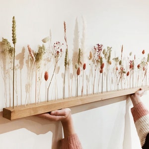 Wooden dried flower arrangement with tall stems and small blooms