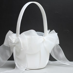 White wedding flower basket with bow ribbons and pearl embellishments