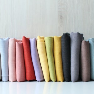Stonewashed linen napkins set, folded in multiple colors including pink, red, yellow