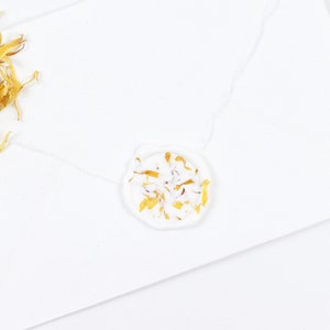 White wax seal with yellow dried petals for wedding invitations