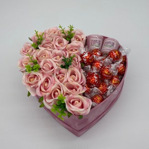 Heart-shaped gift box with pink roses and wrapped chocolates