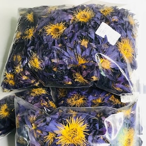Dried blue lotus flowers in clear bag, purple petals with yellow centers