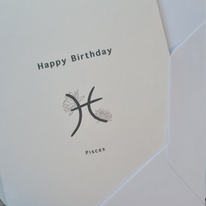 Black-and-white birthday card with 'Happy Birthday' and Pisces symbol
