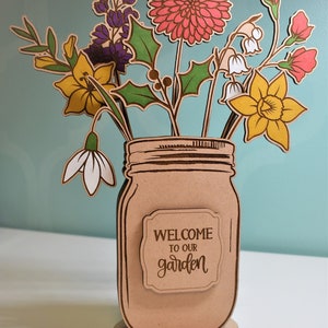 Handcrafted mason jar centerpiece with engraved label and colorful wooden flower bouquet