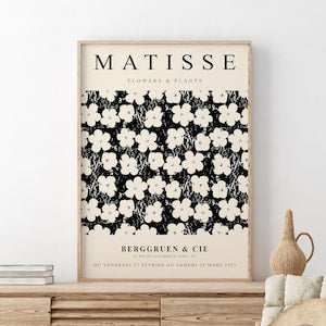Framed Matisse flower print with white blossoms on dark background and title text at top