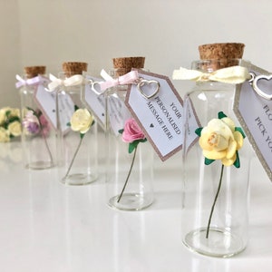 Set of glass flower bottles with roses and gift tags