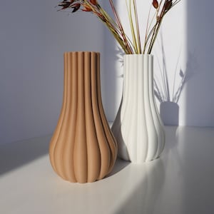 Minimalist ribbed eco-friendly vase set with one beige and one white, holding dry flowers