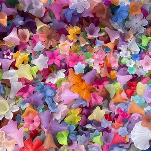Colorful lucite flower-shaped beads, assorted colors in a pile