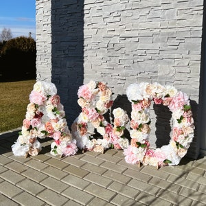 Large freestanding flower letters with pink and white blooms, forming LOVE