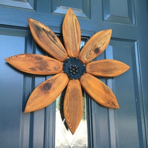 Wood flower wall decoration with carved petals and dark center medallion