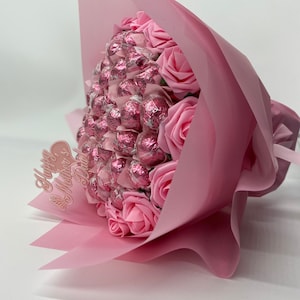 Pink hand-tied chocolate and flower bouquet with wrapped chocolates and pink roses