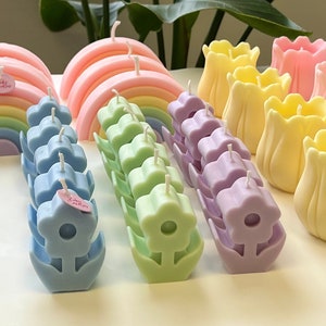 Pastel flower-shaped pillar candles in decorative holder, assorted colors