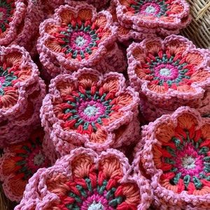Pink crochet flower appliques with multicolor centers in circular motifs