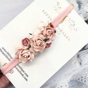 Dusky pink baby headband with three fabric rose flowers on the side